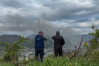 Local residents observe smoke rising above buildings following a recent drone attack on the Tuapse oil refinery in Tuapse, Krasnodar region